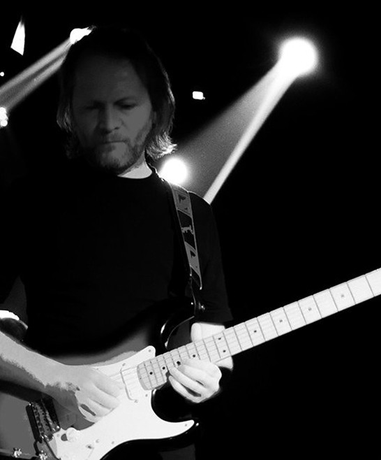Barış Kıran playing a Stratocaster, black and white